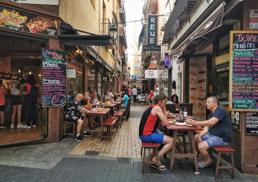 tapas alley, strada del centro di benidorm con molti ristoranti e gente seduta ai tavolini all'aperto