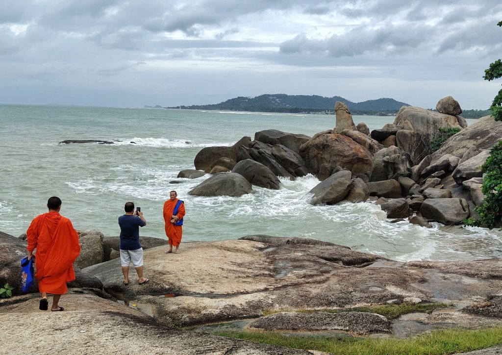 Monaci buddhisti su una scogliera sul mare in Thailandia