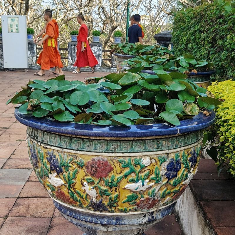 monaci buddhisti che camminano le giardino di un tempio thailandese