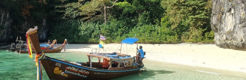 spiaggia da sogno con barca tradizionale in Thailandia